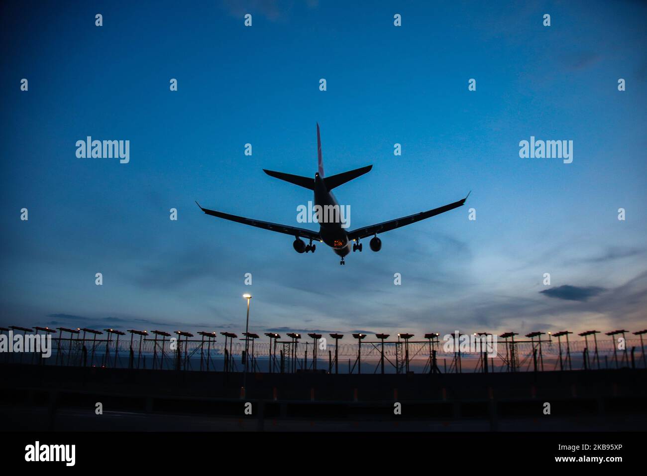 Airplane silhouettes while on final approach landing, during the sunset ...
