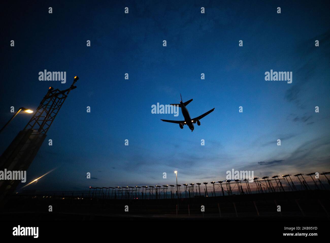 Airplane silhouettes while on final approach landing, during the sunset ...