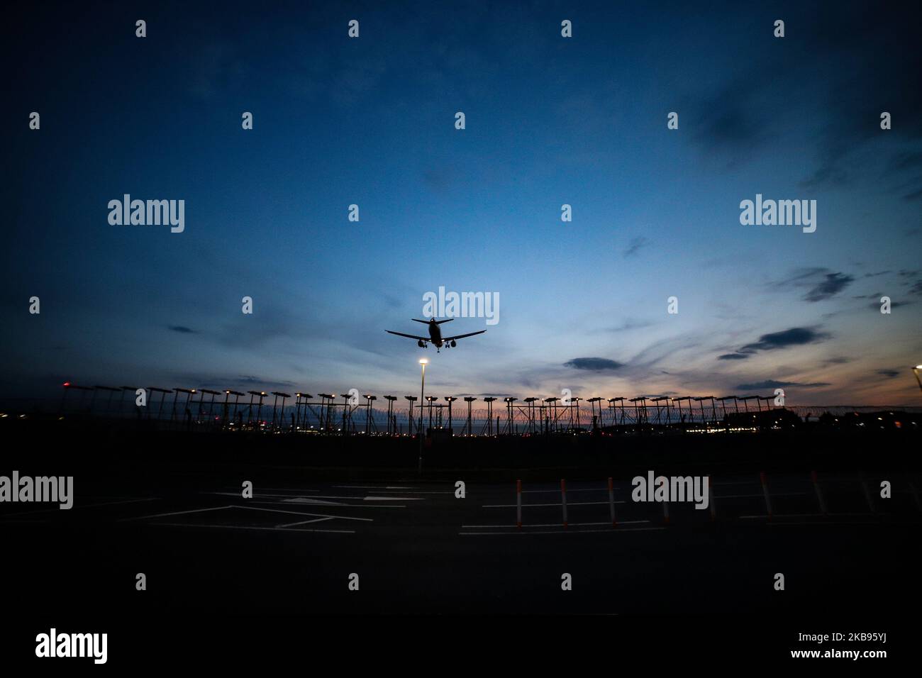 Airplane silhouettes while on final approach landing, during the sunset ...