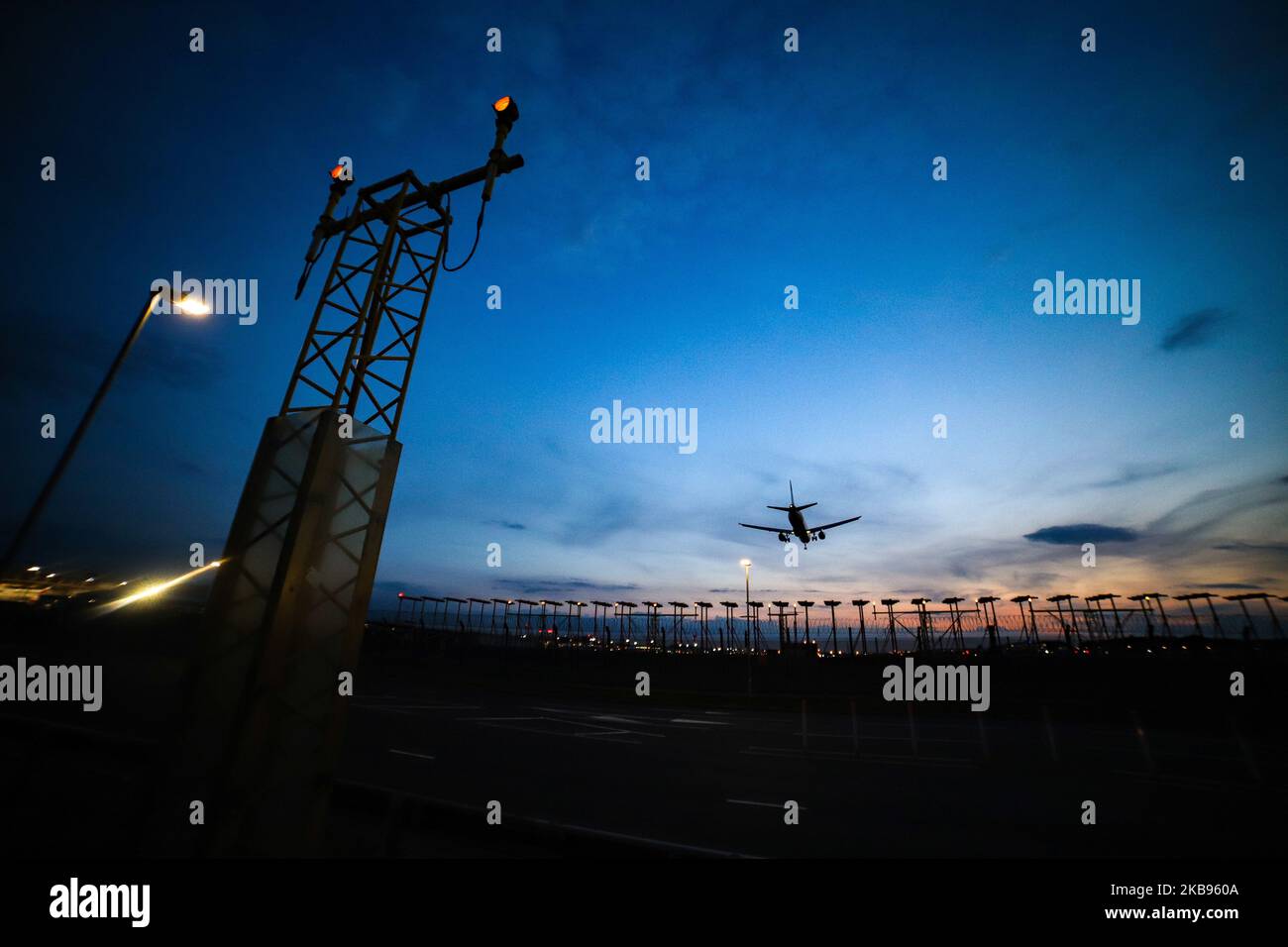 Airplane silhouettes while on final approach landing, during the sunset ...
