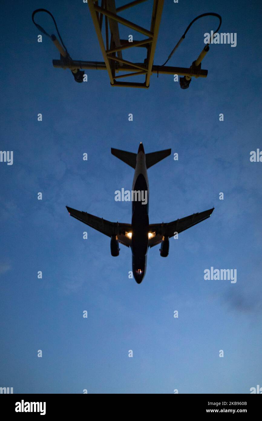 Airplane silhouettes while on final approach landing, during the sunset ...