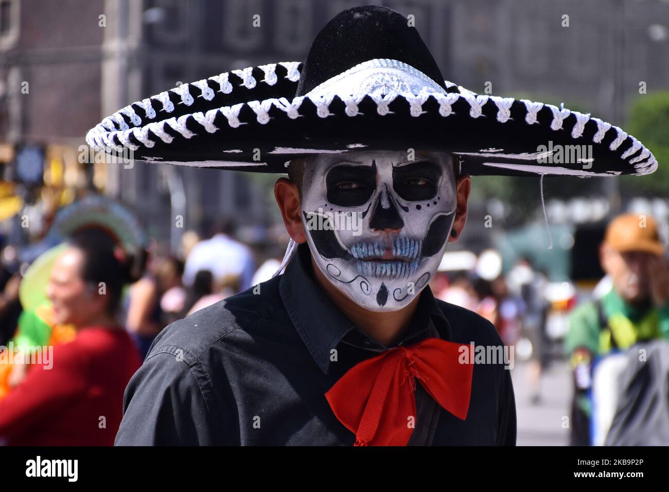 People with the skull painted face and dressed as charro take part