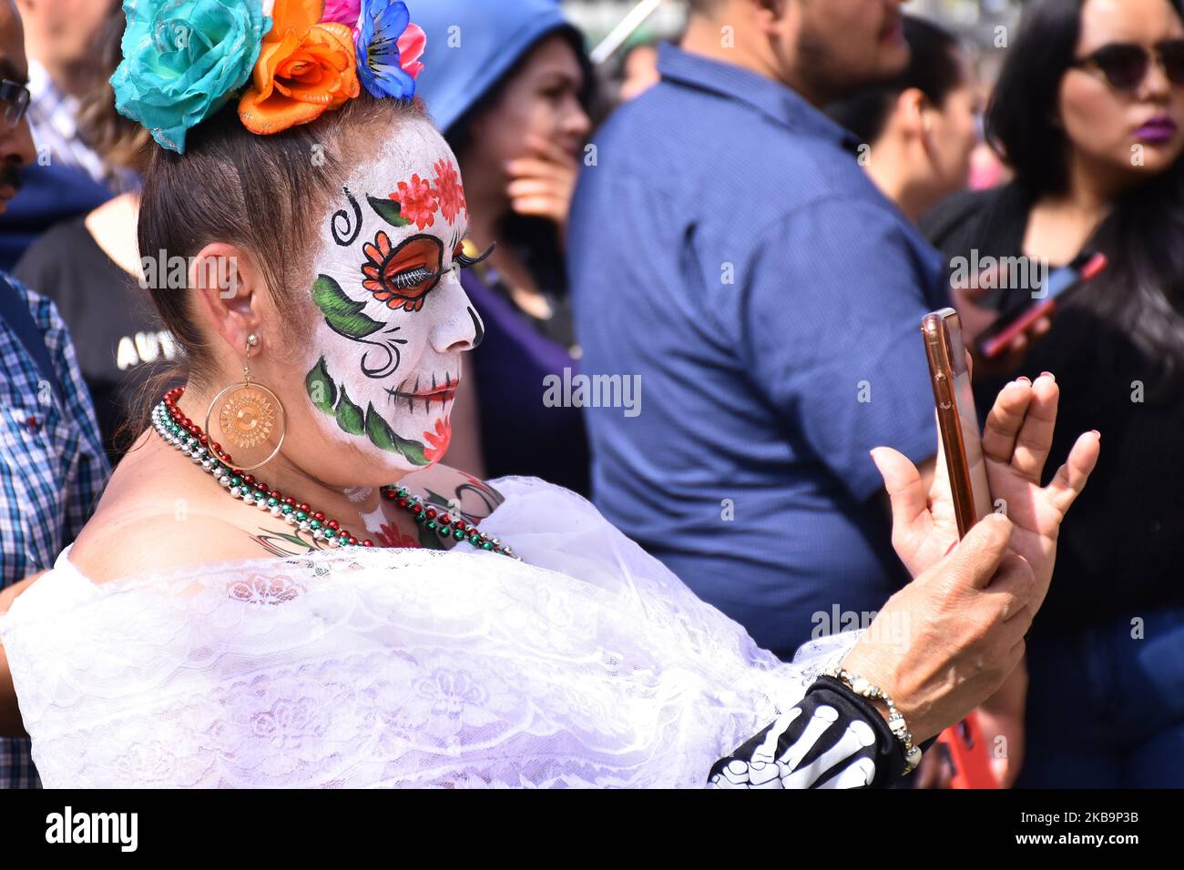 Tourist with the skull painted face take a photo during the mega