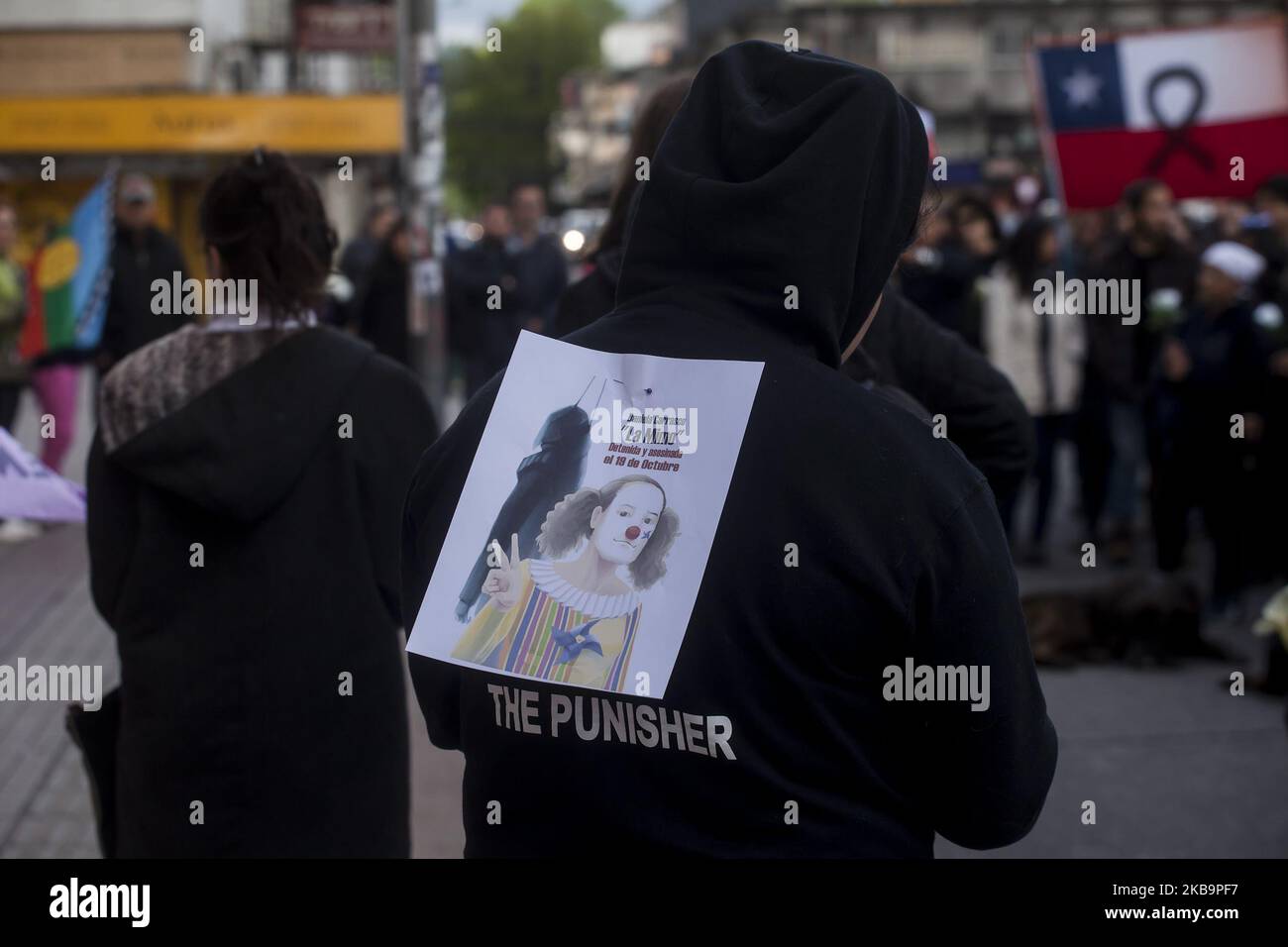 Osorno, Chile. 1 November 2019. Protester carries on his back the image of Daniela Carrasco the 'mime' that was found hanged. Dressed in black, with flowers in their hands, with posters and in silence, a group of women marched to remember those killed during protests throughout the country in Osorno, Chile. (Photo by Fernando Lavoz/NurPhoto) Stock Photo