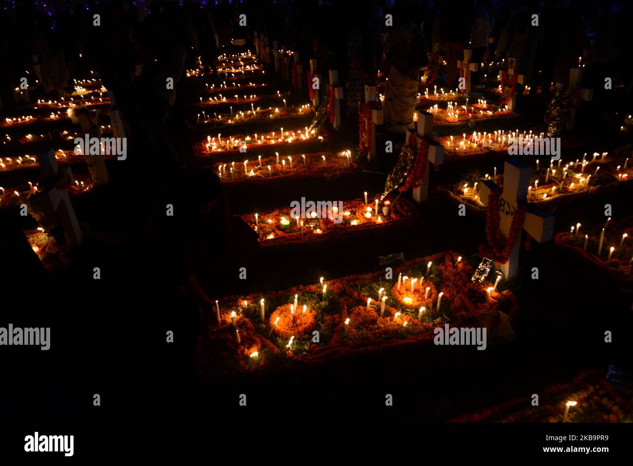 Bangladeshi Catholics Pray After Lighting Candles For Their Departed Relatives At A Cemetery In