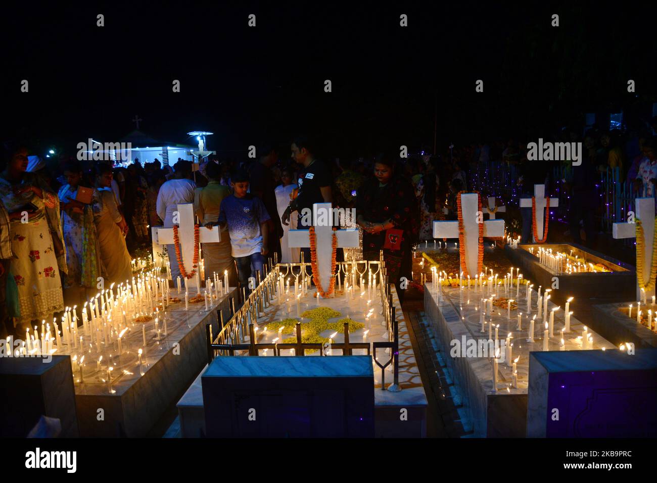 Bangladeshi Catholics pray after lighting candles for their departed