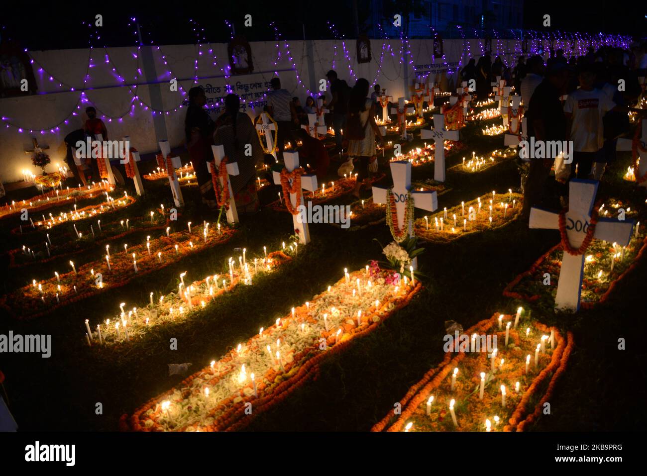 Bangladeshi Catholics pray after lighting candles for their departed