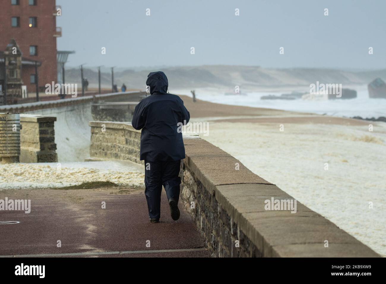 A person in Capbreton walking near the ocean on November 3, 2019 during the Amelie storm. Some 100,000 households were deprived of electricity in south western France, where the Atlantic coast was swept by storm Amelie, causing damage but no casualties, according to an initial assessment by the emergency services and the prefectures. (Photo by Jerome Gilles/NurPhoto) Stock Photo