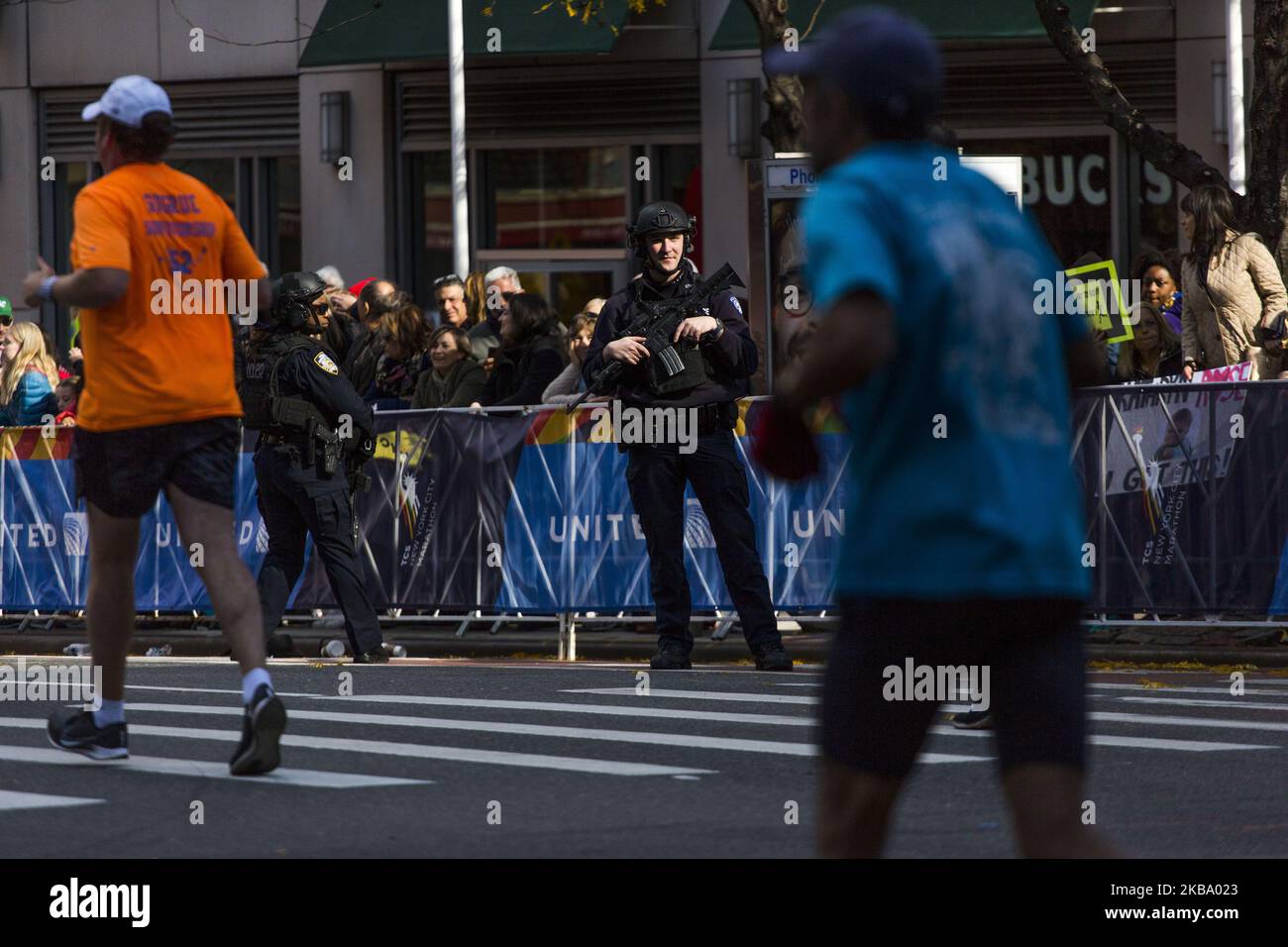 An armed NYPD officer watches the New York City Marathon Sunday ...