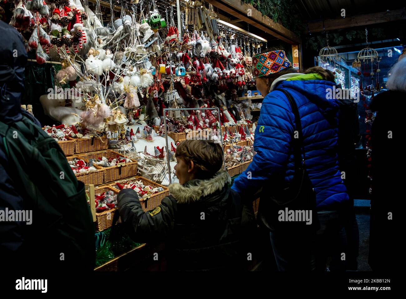 Visitors enjoy Christmas lights and small outdoor stands with souvenirs