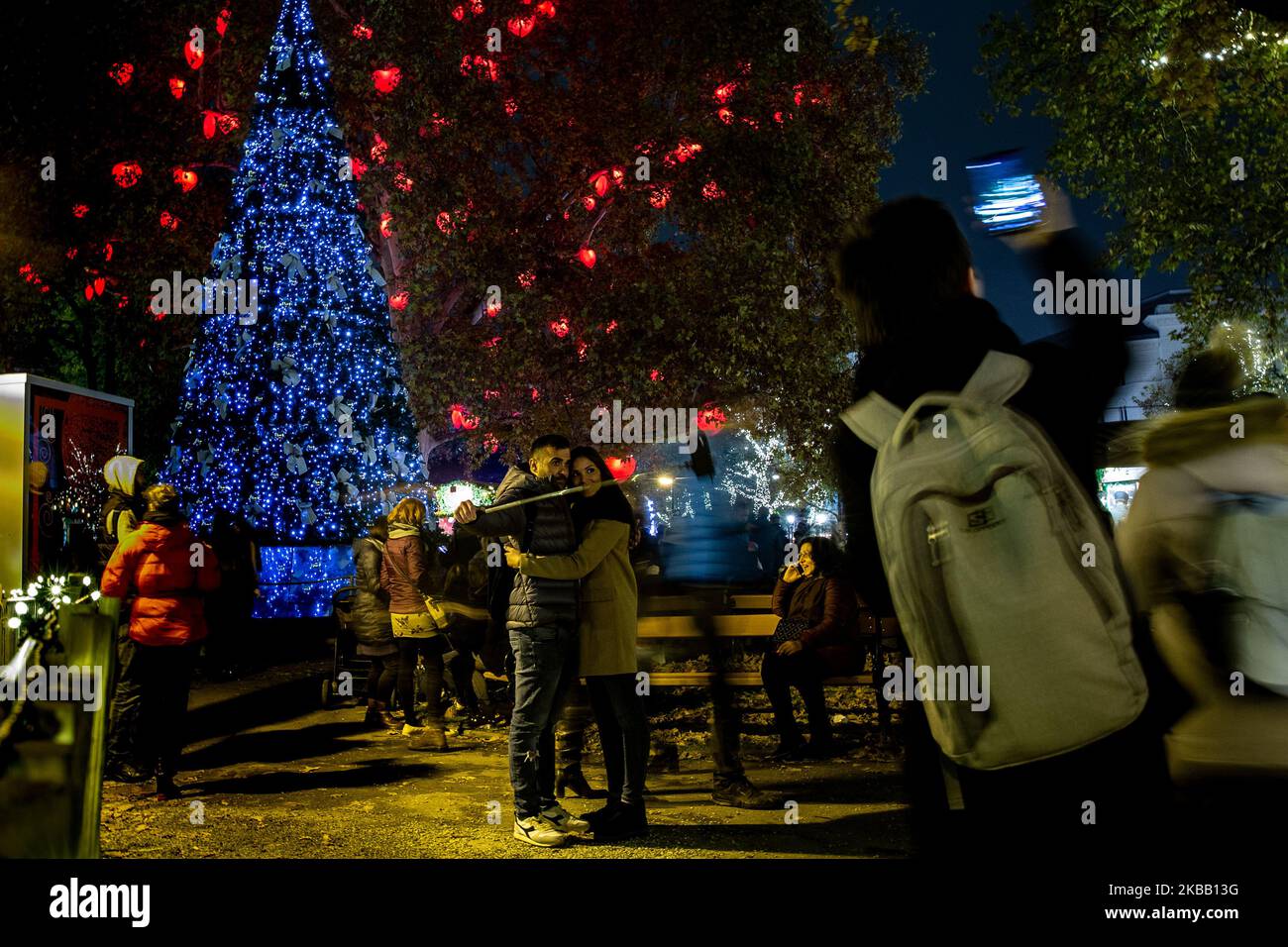Visitors enjoy Christmas lights and small outdoor stands with souvenirs