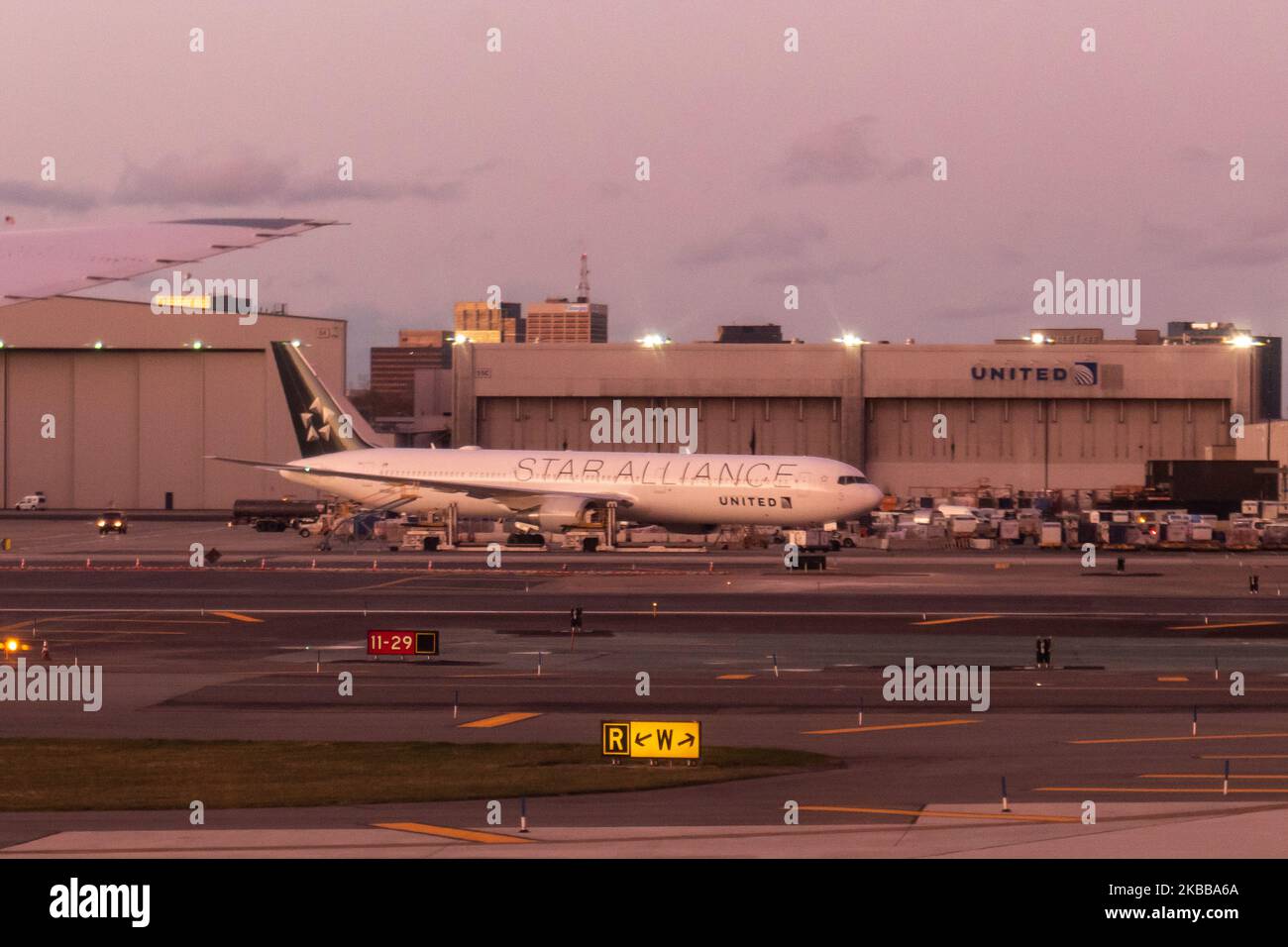 Boeing 777 of United in Star Alliance livery in front of a United Airlines Hangar. General view of United Airlines airplanes during the sunset magic hour at Newark Liberty International Airport EWR / KEWR in Newark and Elizabeth, New Jersey, USA as seen on November 12, 2019. United UA UAL is the 3rd largest airline in the world, member of Star Alliance aviation alliance with headquarters at Willis Tower in Chicago and multiple hubs across the United States with Newark one of the majors. (Photo by Nicolas Economou/NurPhoto) Stock Photo