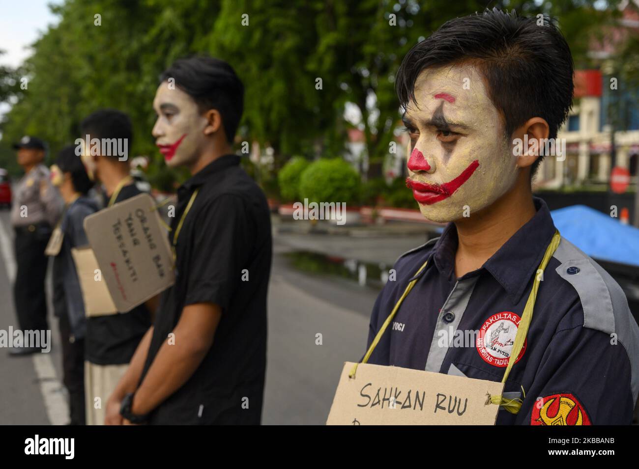 Humanitarian activists put on their faces and carried pamphlets when they held the Kamisan Action in front of the Central Sulawesi House of Representatives Office in Palu, Central Sulawesi, Indonesia on November 21, 2019. This 18th action carried the theme of Mining and stated that it refused to revise the Mineral and Coal Law . They also demanded that the government review the permit granted to PT Citra Palu Mineral to explore gold mining in Poboya, Palu City next year. (Photo by Basri Marzuki/NurPhoto) Stock Photo