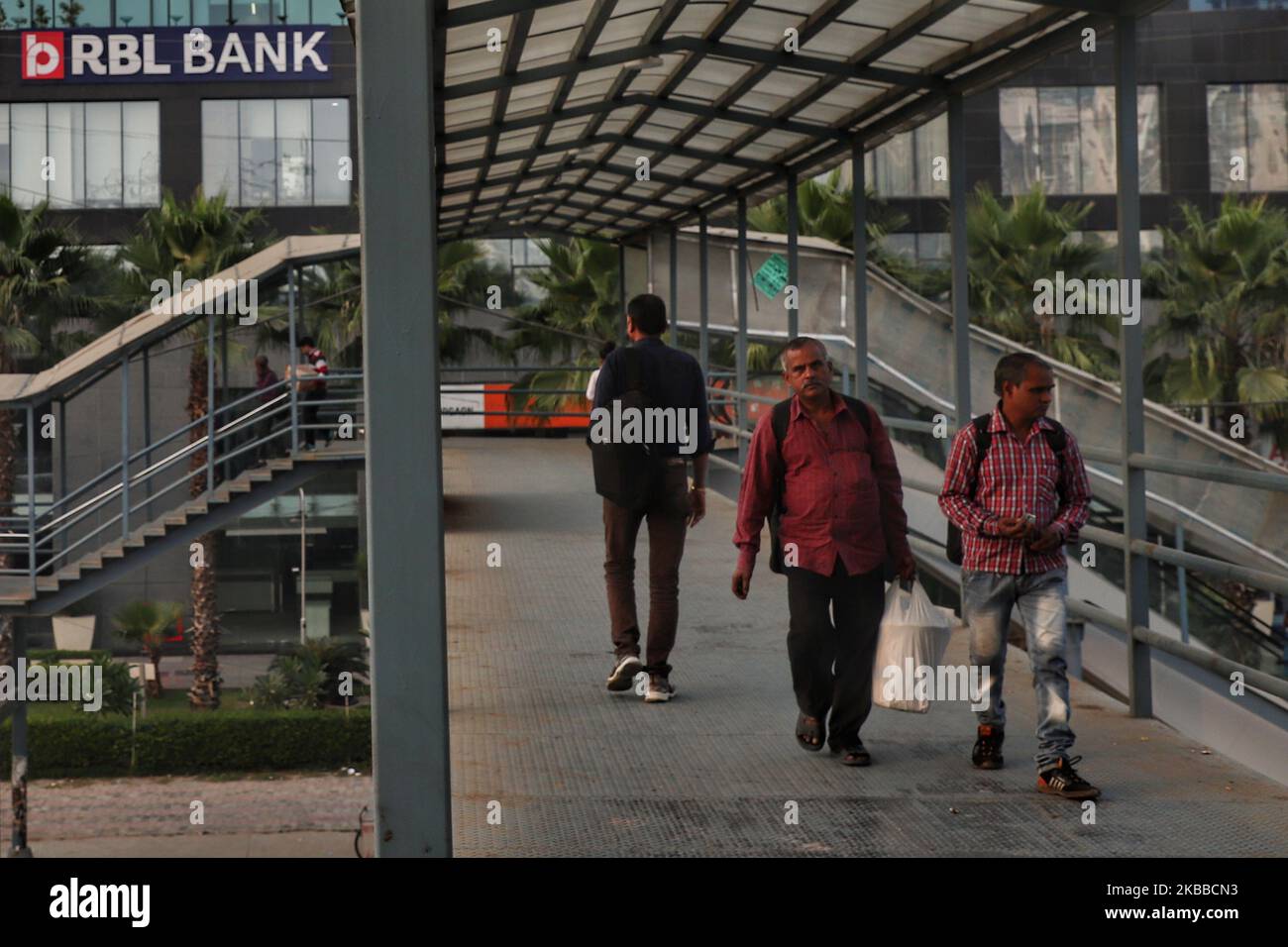 Indian men walk over a Foot over bridge with RBL Bank board installed at a branch in Gurugram on the outskirts of New Delhi India on 22 November 2019 (Photo by Nasir Kachroo/NurPhoto) Stock Photo
