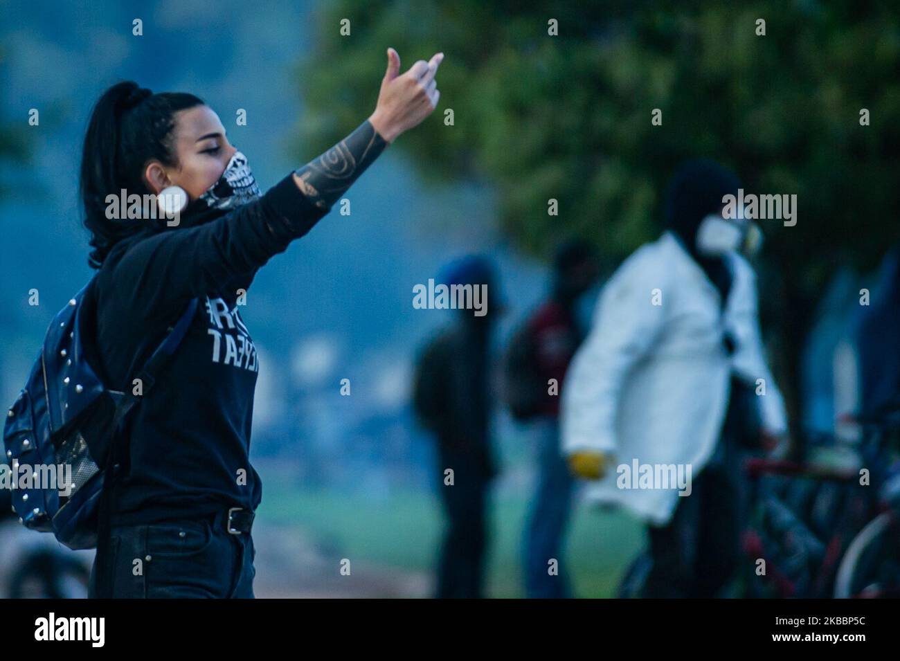 Student gives the middle finger as they shout slogans during a vigil for Dilan Cruz, a young demonstrator who had been wounded by a member of the Mobile Anti-Disturbance Squadron (ESMAD) during a protest against the Colombian government and died yesterday, in Bogota on November 26, 2019. (Photo by Juan Carlos Torres/NurPhoto) Stock Photo