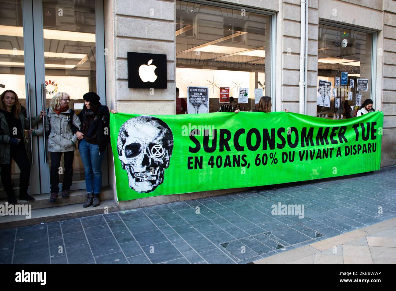 Activists sitting and blocking the apple store in Bordeaux, France, on 29 November 2019. Block friday against black friday makes actions in Bordeaux in France, starting by a march with the march for the climate, some activist sit and block the stores galeries lafayette and the apple store tin the center of Bordeaux, by the associations of youth for the climate, extinction rebellion, and AnvCop21, some activist sit in the apple store before the police get them out. (Photo by Jerome Gilles/NurPhoto) Stock Photo