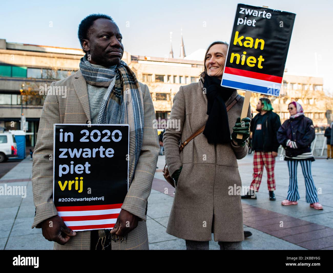 A black man and a white woman are holding both Anti Black Piet placards, during the Anti Black Piet rally in Eindhoven, on November 30th, 2019. (Photo by Romy Arroyo Fernandez/NurPhoto) Stock Photo