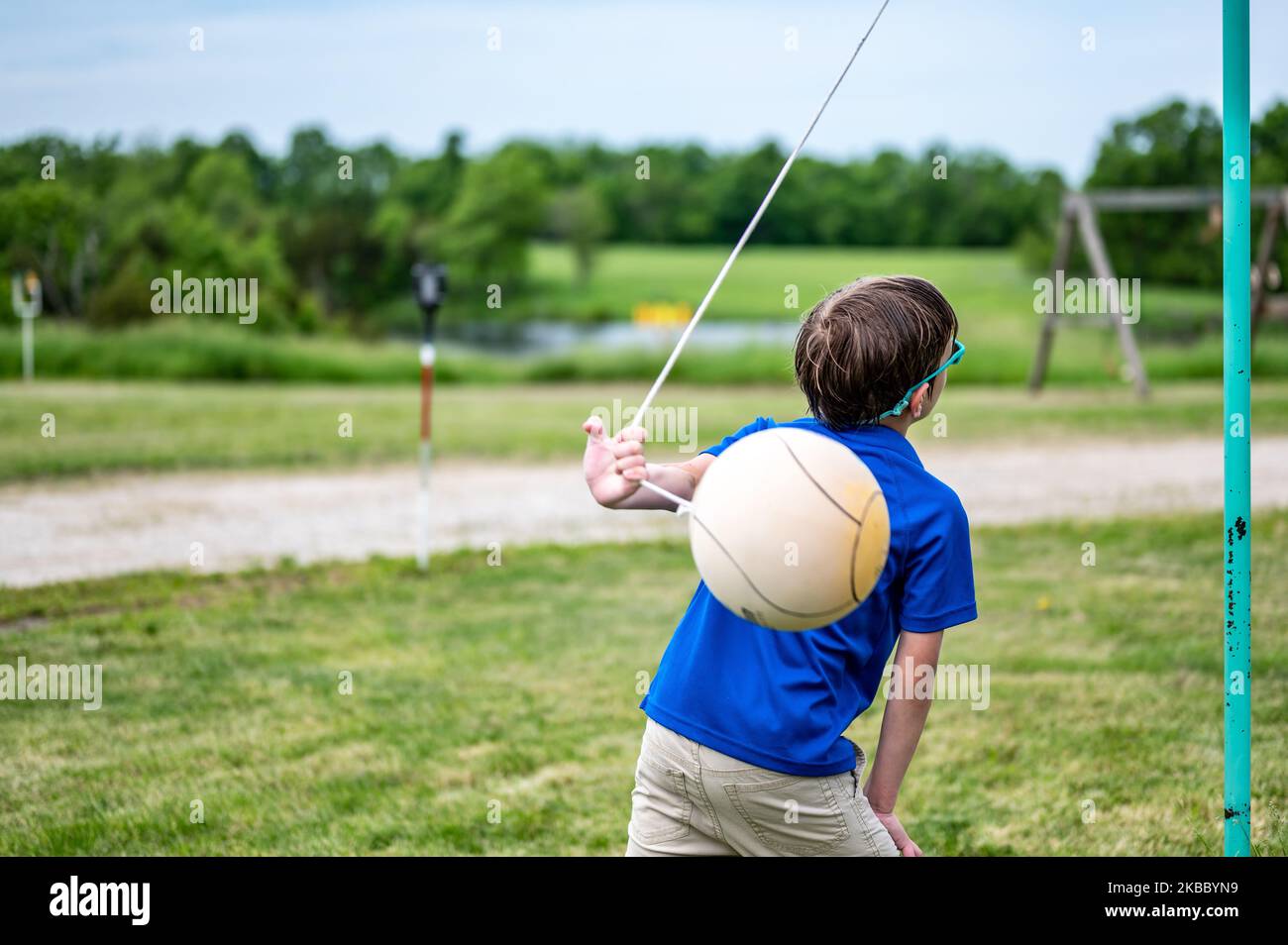 Tetherball being hit and roped in a game with a young boy Stock Photo