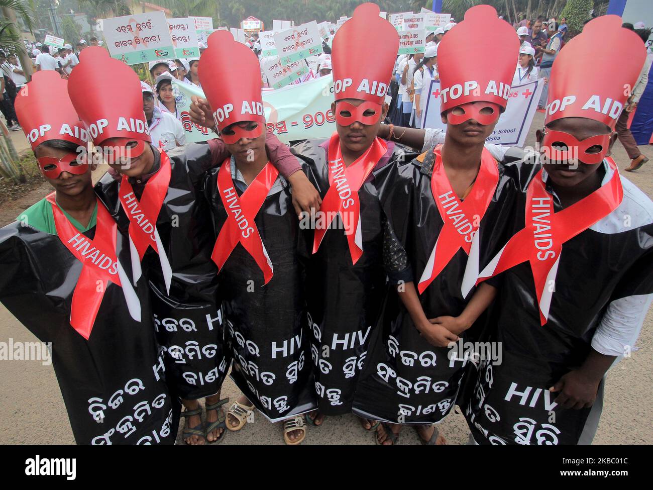 Students wear red ribbon and hold awareness placards as they take part