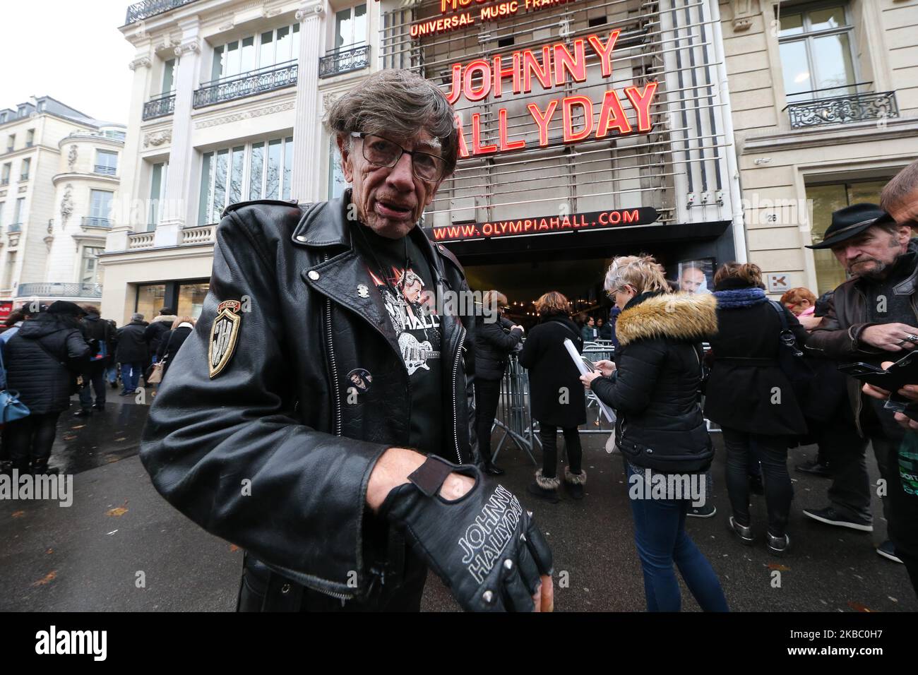 A fan of the French singer Johnny Hallyday poses in front of the Olympia Hall in Paris where a tribute was paid to this legend of French music on Sunday, December 1, 2019, almost two years after his death. For the occasion, the letters of his name shone in red in the neon lights of the famous facade of the Olympia. Johnny Hallyday died at the age of 74 on the night of December 5th 2017 after a battle with lung cancer. (Photo by Michel Stoupak/NurPhoto) Stock Photo