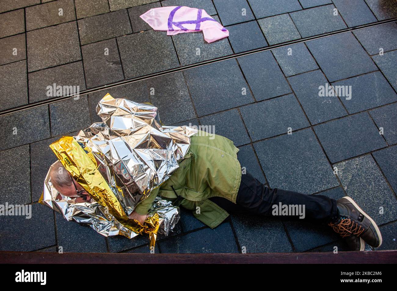 An old man is lying on the floor during an XR action, during the warning alarm, in Rotterdam, on December 2nd, 2019. (Photo by Romy Arroyo Fernandez/NurPhoto) Stock Photo