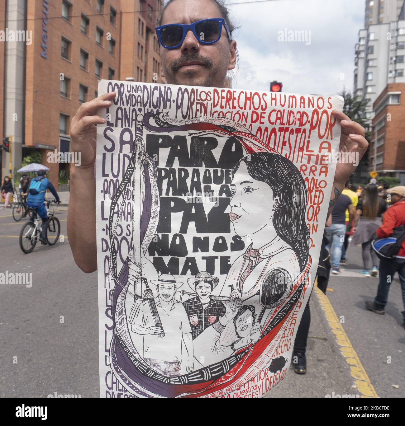 People hold a poster in a musical protest against the government of President Iván Duque in Bogotá. (Photo by Daniel Garzon Herazo/NurPhoto) Stock Photo