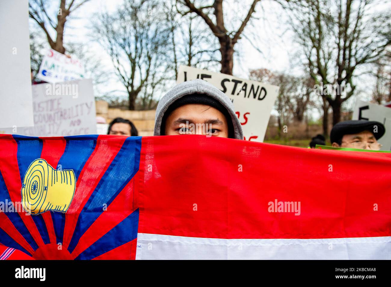 A man is hiding behind a flag, during a Rohingya solidarity rally in ...