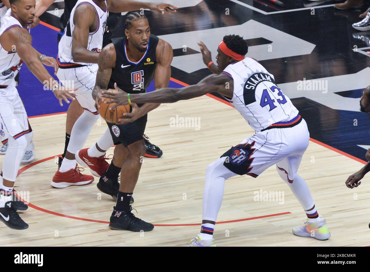 Kawhi Leonard #2 of the Los Angeles Clippers passes to the player of his team surrounded by rivals during the Toronto Raptors vs Los Angeles Clippers NBA regular season game at Scotiabank Arena on December 11, 2019, in Toronto, Canada (Score after first half 46:64) (Photo by Anatoliy Cherkasov/NurPhoto) Stock Photo