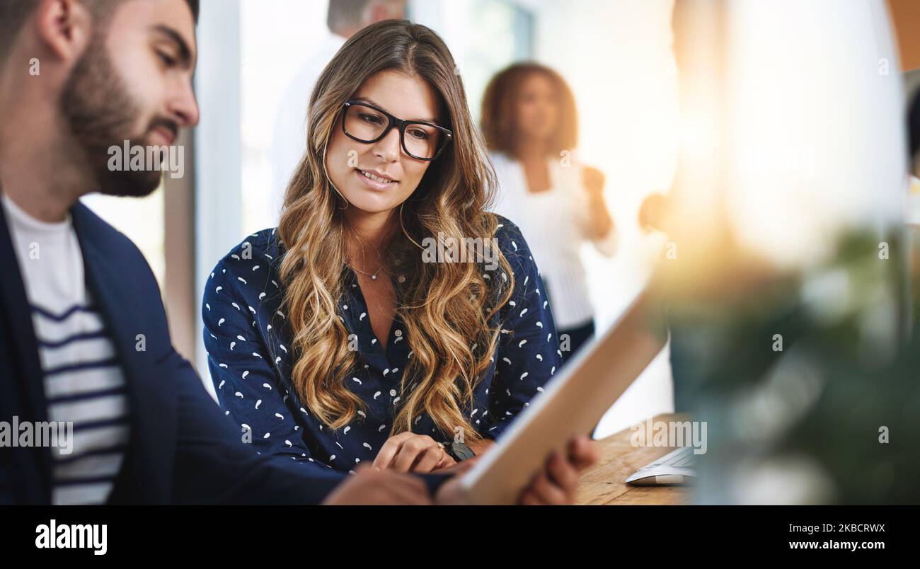 Sharing digital ideas. colleagues working together on a digital tablet in an office. Stock Photo