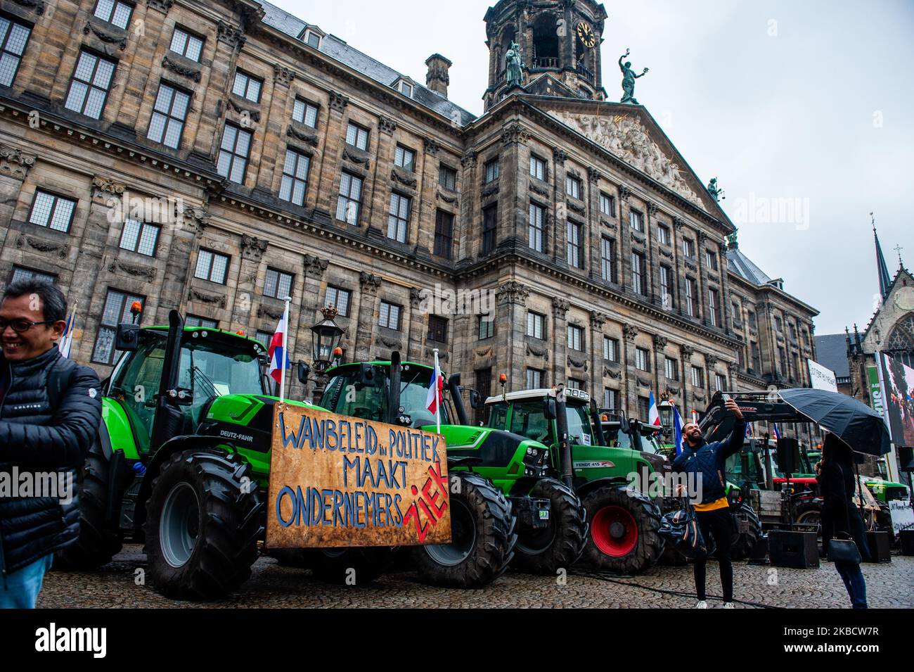 Some tourists are taking selfies in front of the group of tractors that