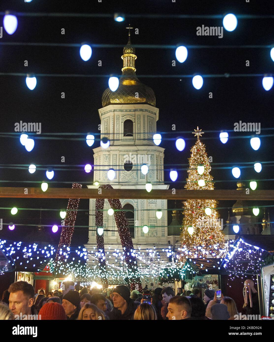 The main Christmas Tree of Ukraine lit up at St. Sophia's Square, in Kiev, Ukraine, 19 December, 2019. The main Ukrainian Christmas tree which is more than 20 meters high, decorated with some one thousands candy toys and about 4 kilometers of glowing garlands, as local media reported. The characters from the ballet 'Nutcracker' and Ukrainian fairy tales installed around the tree. The Christmas tree lighting ceremony took place in Ukrainian capital on St. Nicholas Day on December 19, 2019. (Photo by STR/NurPhoto) Stock Photo