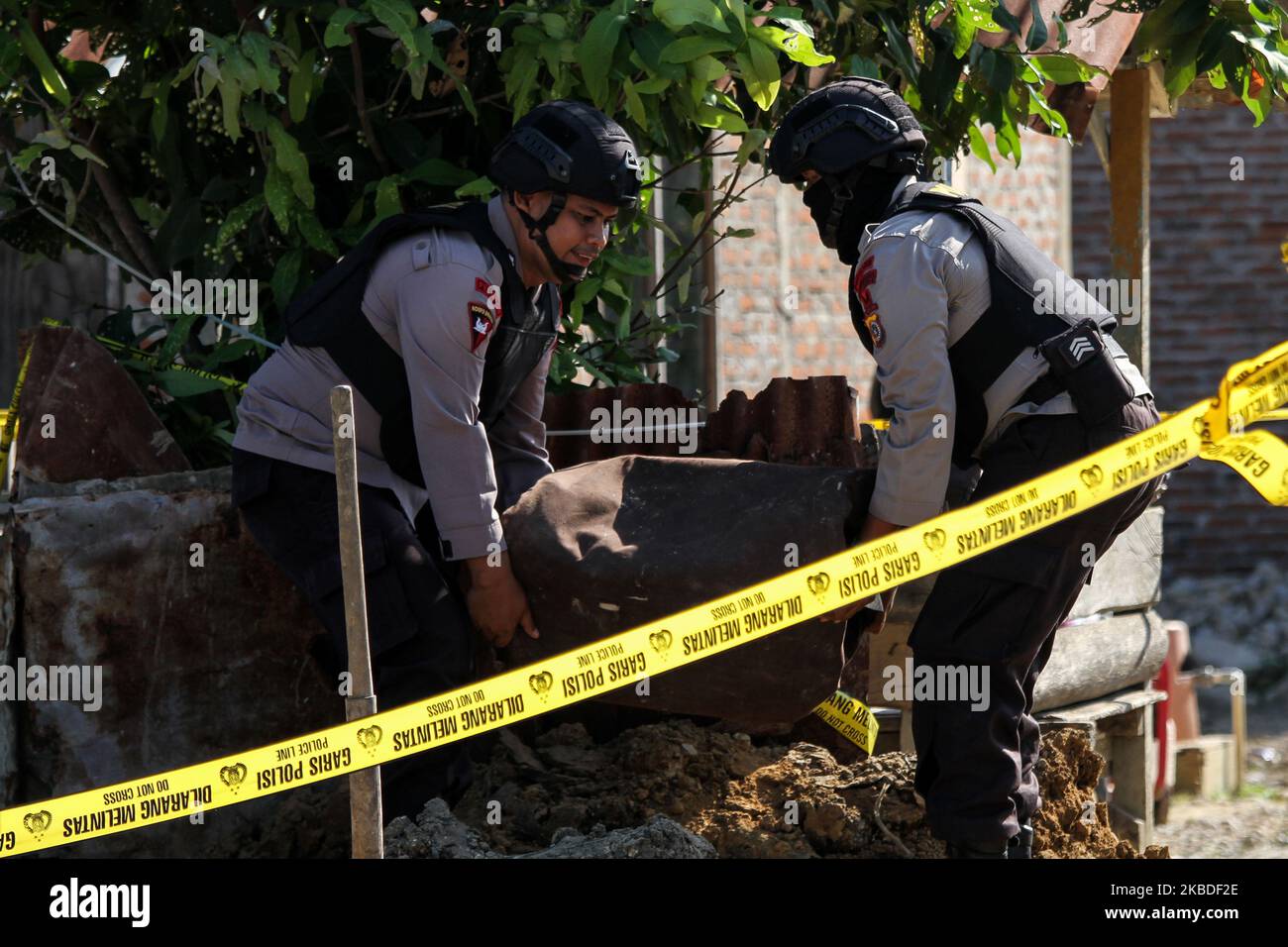 Members of the Indonesian bomb squad evacuated an object suspected of being a bomb at a residential area in Lhokseumawe, on December 25, 2019, Aceh, Indonesia. The object, which has a length of around 50 cm, was discovered accidentally by residents who were digging in the yard, allegedly as a remnant of a bomb from a conflict that had occurred in Aceh. (Photo by Fachrul Reza/NurPhoto) Stock Photo
