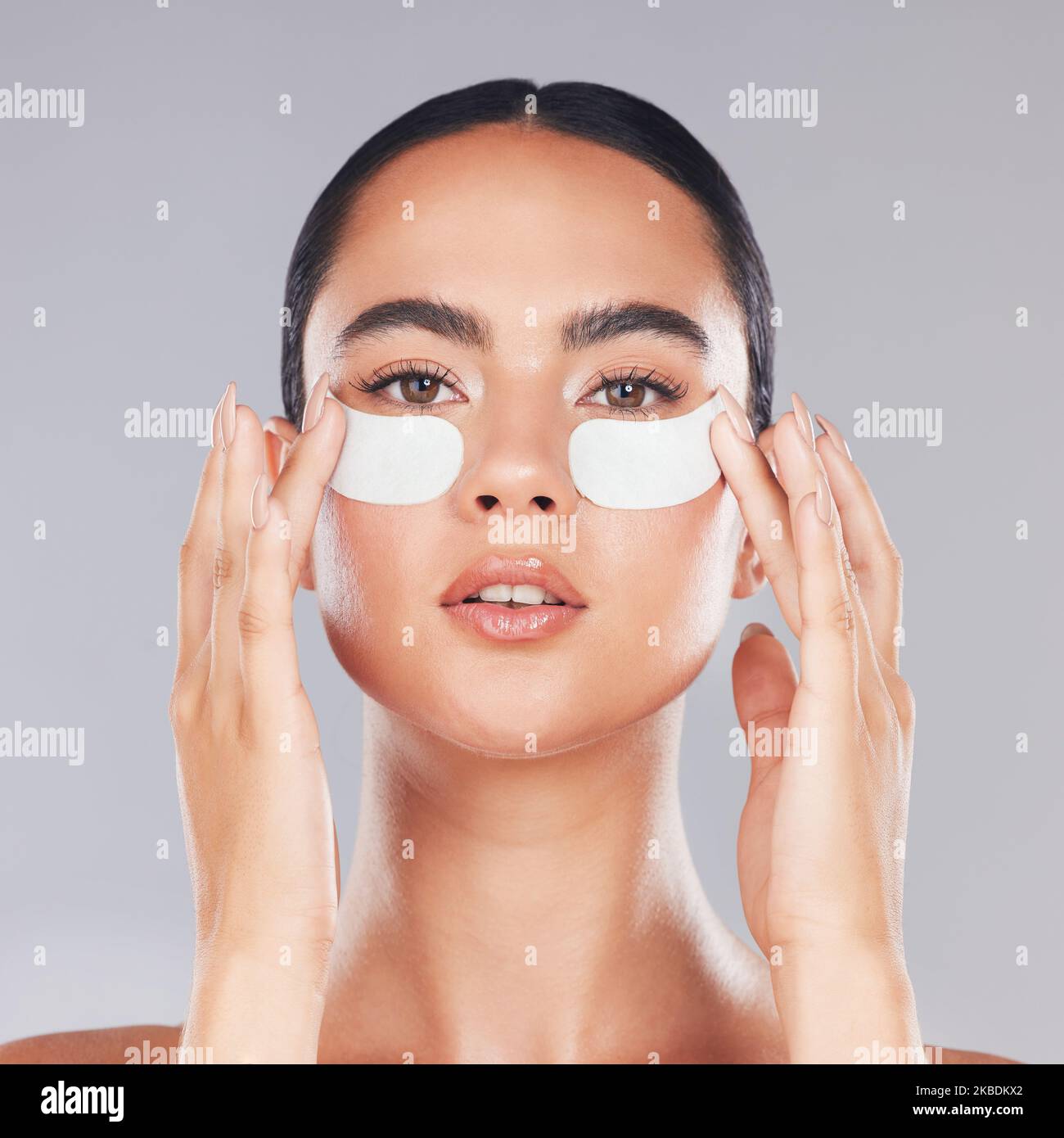 Face, skincare and woman with eye patches on a gray studio background
