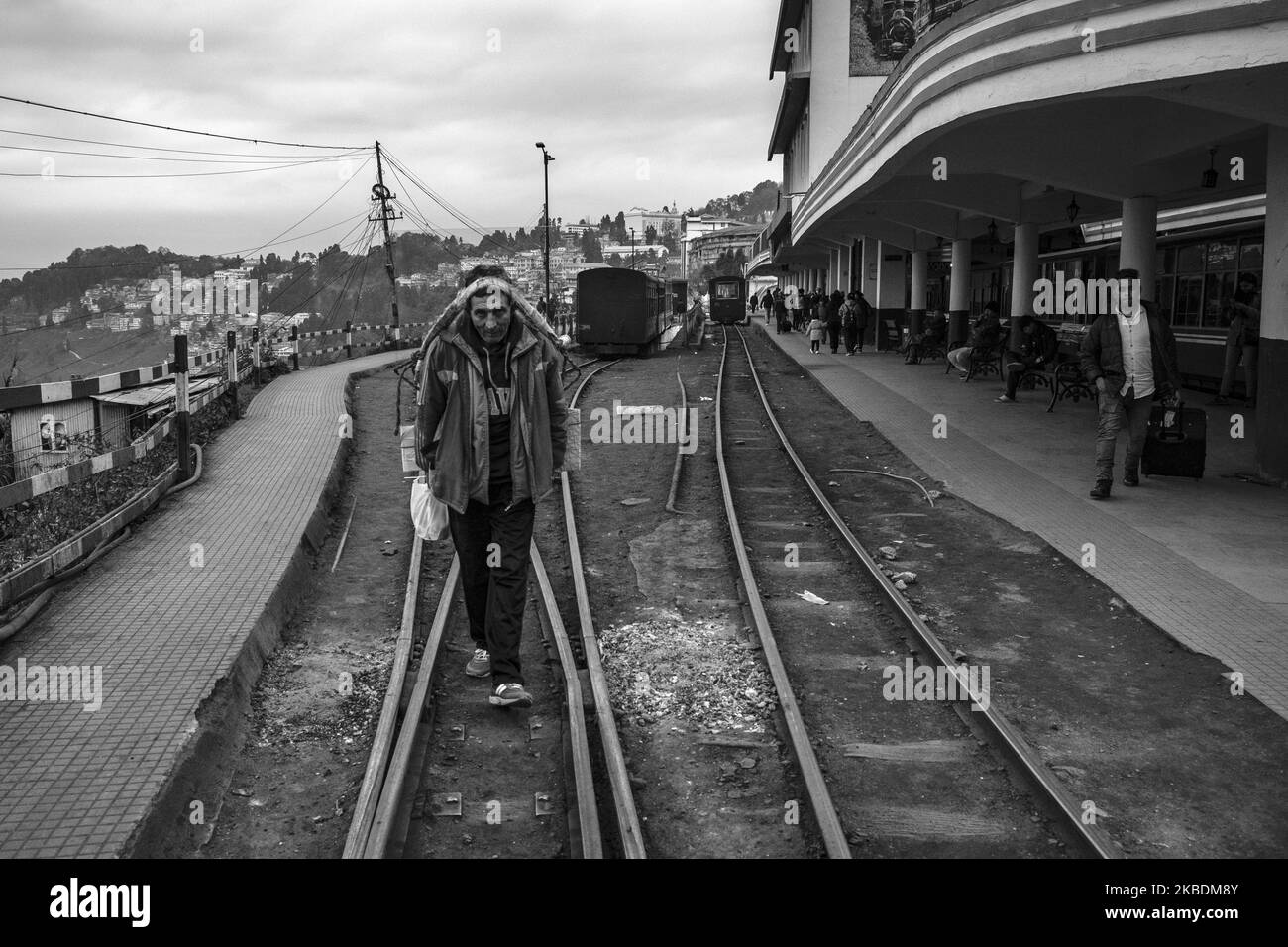 (EDITOR'S NOTE: Image was converted to black and white) A local hawker passing the railway tracks in Darjeeling, India on 20th Dec'19. - Darjeeling Himalayan Railway is one of the oldest two feet gauge railway in India which was settled by the British. Now it has been declared as a UNESCO World Heritage site on 5th December 1999. (Photo by Dipayan Bose/NurPhoto) Stock Photo