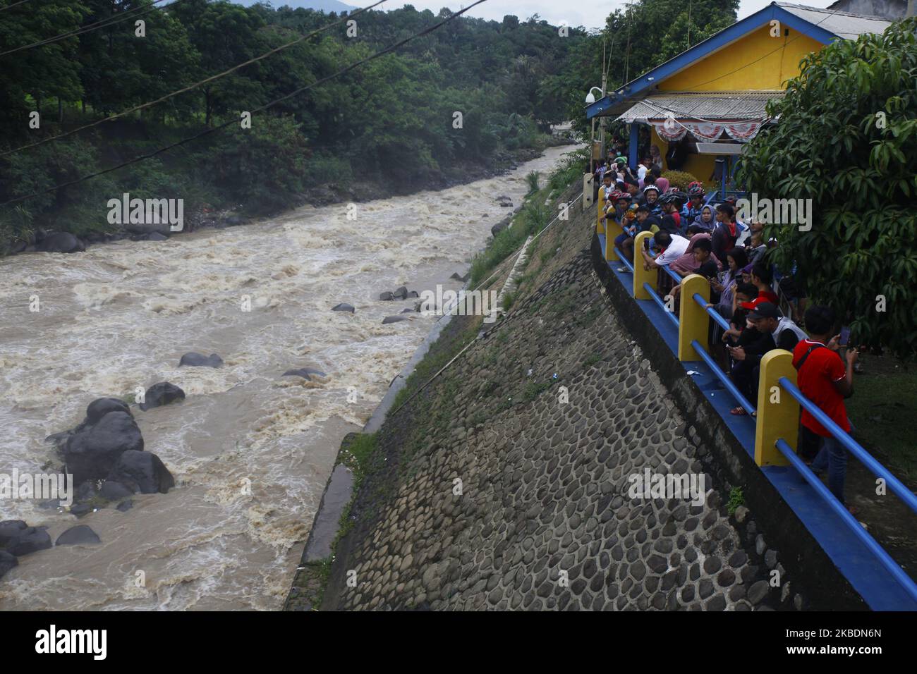 A number of people watched during the Ciliwung river's water level rise in the Katulampa Dam, Bogor City, West Java, on January 1, 2020. High-intensity rain that flushed the Bogor region since Tuesday (31 December 2019) caused the water level in the Katulampa Dam to rise. and the impact of Jakarta flooding. According to the National Disaster Management Agency (BNPB), 9 people died and 19,709 people were displaced by floods in Jakarta. (Photo by Adriana Adie/NurPhoto) Stock Photo