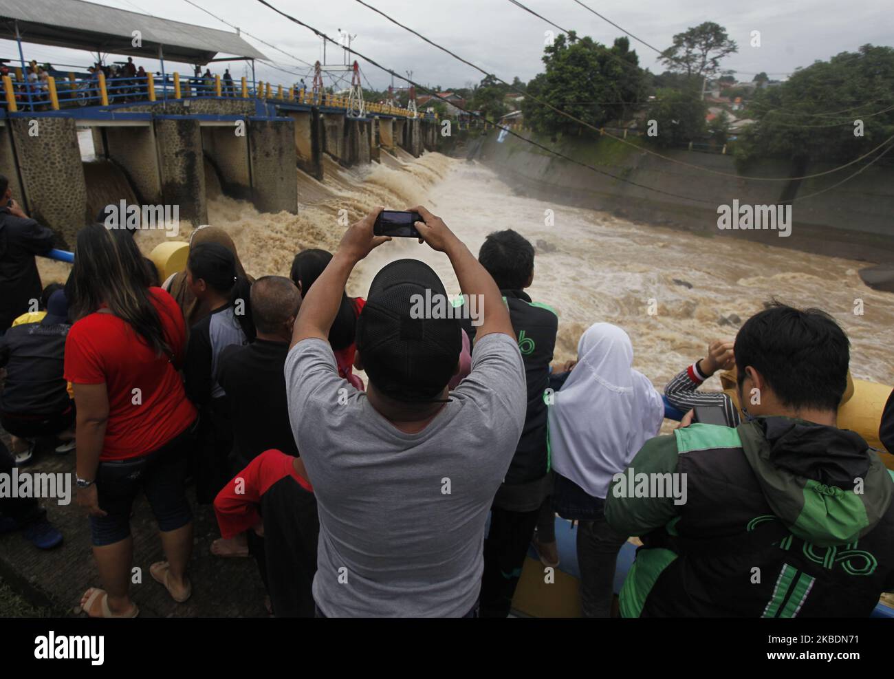 A number of people watched during the Ciliwung river's water level rise in the Katulampa Dam, Bogor City, West Java, on January 1, 2020. High-intensity rain that flushed the Bogor region since Tuesday (31 December 2019) caused the water level in the Katulampa Dam to rise. and the impact of Jakarta flooding. According to the National Disaster Management Agency (BNPB), 9 people died and 19,709 people were displaced by floods in Jakarta. (Photo by Adriana Adie/NurPhoto) Stock Photo