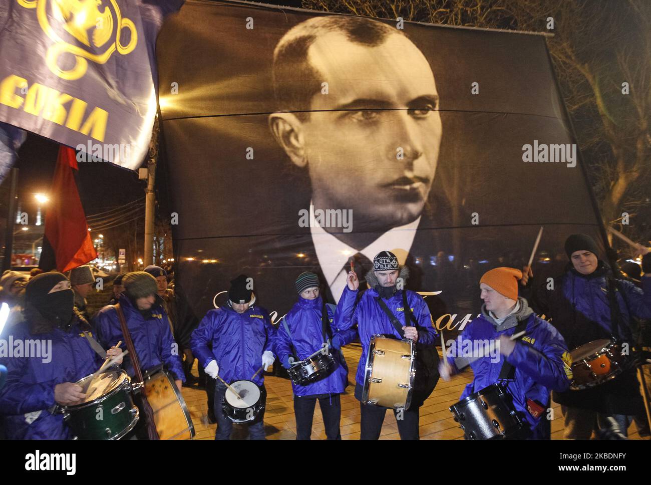 Drummers stand nexto to a banner with Stepan Bandera portrait during a torchlight procession dedicated to the 111th of Stepan Bandera birthday in center of Kyiv, Ukraine, on 1 January 2020. Members and supporters of 'Svoboda' ('Freedom') nationalistic party attended the torch march to mark leader and ideologist of Ukrainian national movement Stepan Bandera birthday. (Photo by STR/NurPhoto) Stock Photo
