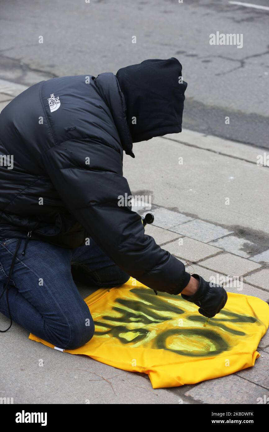 Man paints the words 'No War' on a jacket as Canadians held a protest outside the American consulate in Toronto, Ontario, Canada, on January 04, 2020 to protest against American aggression towards Iran following an American airstrike that killed Iranian Major-General Qassem Soleimani, head of the elite Quds Force, and Iraqi militia commander Abu Mahdi al-Muhandis on Friday January 03, 2020. Canadian protestors denounced the airstrikes ordered by US President Donald Trump and called on Canada to remove its troops from the Middle East and urged Canadian Prime Minister Justin Trudeau to intervene Stock Photo