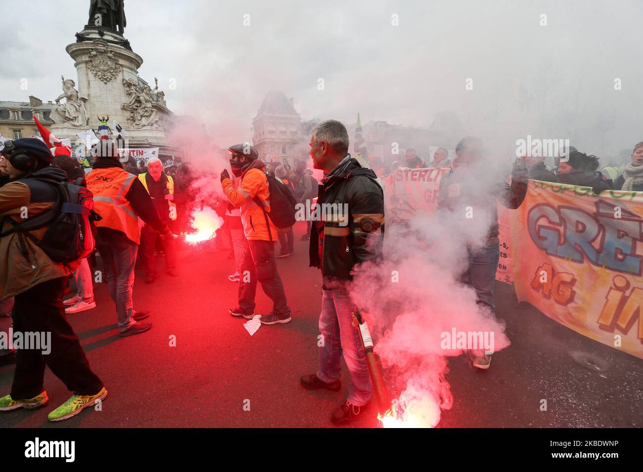 Striking railway workers holds red flares during a demonstration called by French national trade union General Confederation of Labour (CGT) against the pension reform on January 4, 2020, on the Place de la Republique in Paris, on January 4, 2020. After 30 days of strike, unions opposed to the pension reform promise not to give respite next week to the government, before the resumption of consultations on January 7,2020. (Photo by Michel Stoupak/NurPhoto) Stock Photo