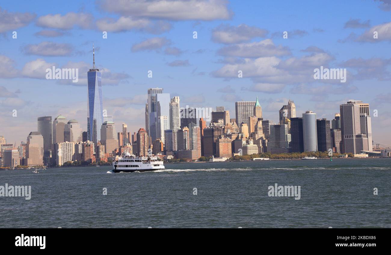 Panoramic view of New York City skyscrapers of (Lower Manhattan) with passenger boat on the foreground, USA Stock Photo