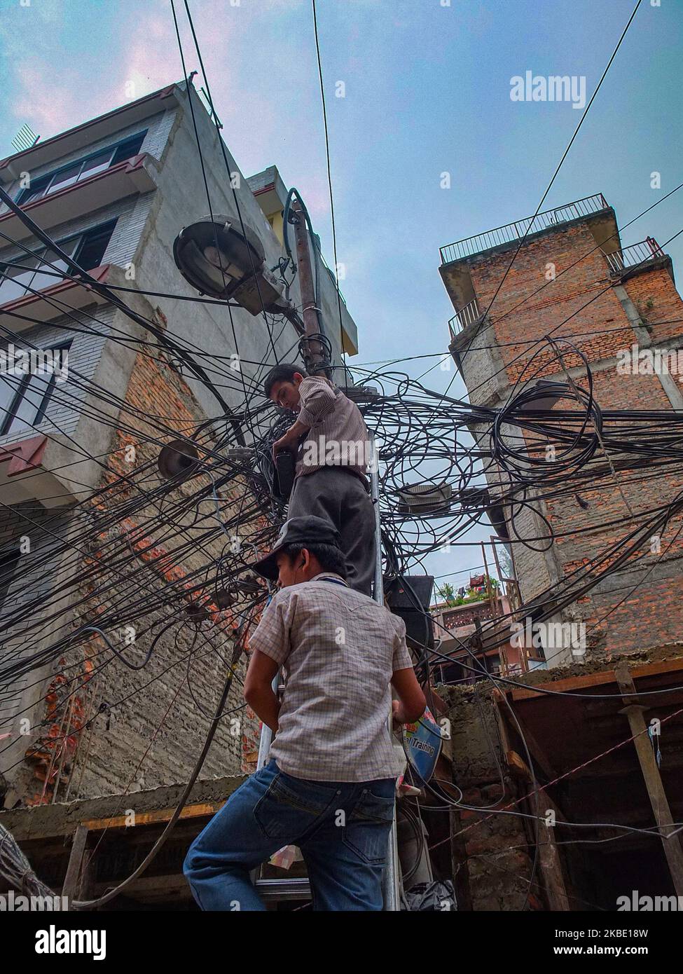 Nepali electricians make repairs using minimal gear and protection in