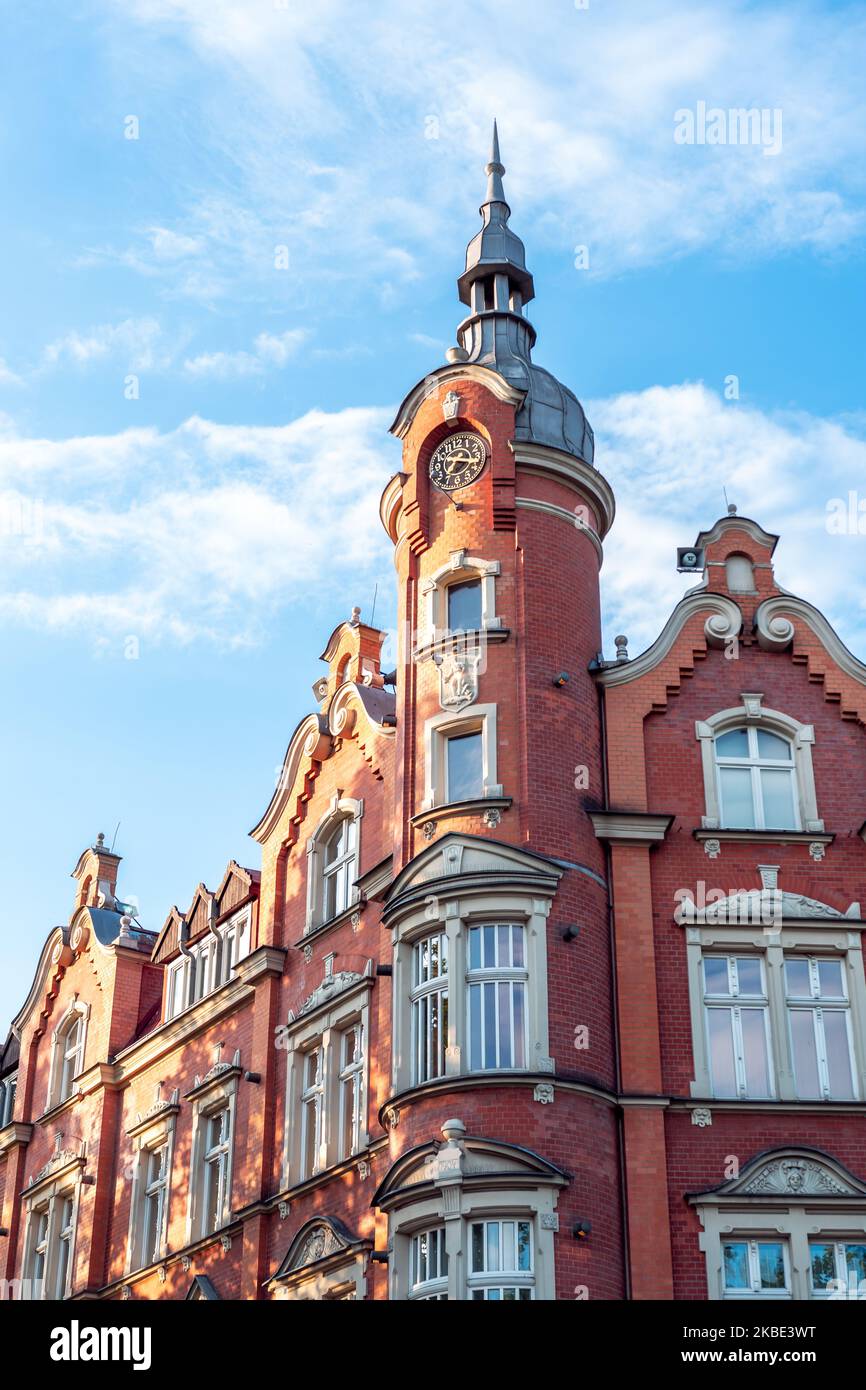 The building of the town hall from 1904. Red brick facade. Beautiful blue sky. The richly decorated facade of the tenement house. Siemianowice Śląskie Stock Photo