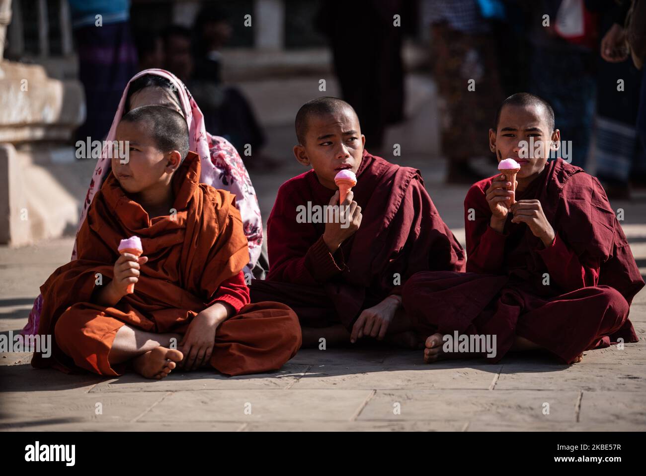 Buddhist novice monks eating ice-cream during Ananda pagoda festival in ...