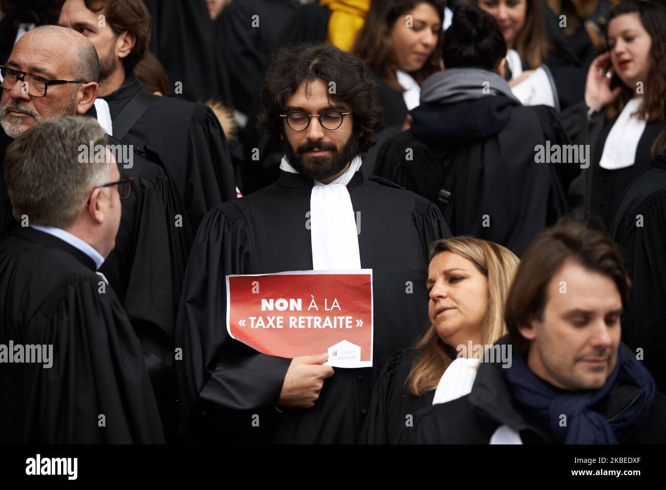 A lawyer holds a placard reading 'No to the retirement tax'. Lawyers gathered in front of the Court House of Toulouse to protest against the planned Macron's retirement reform. Their contributions to the retirement system will double (14% to 28%) but for a pension 30% lower. The Macron's gouvernement plans to change the retirement system pay-as-you-go by a system by points (capitalization). Toulouse. France. January 13th 2020. (Photo by Alain Pitton/NurPhoto) Stock Photo