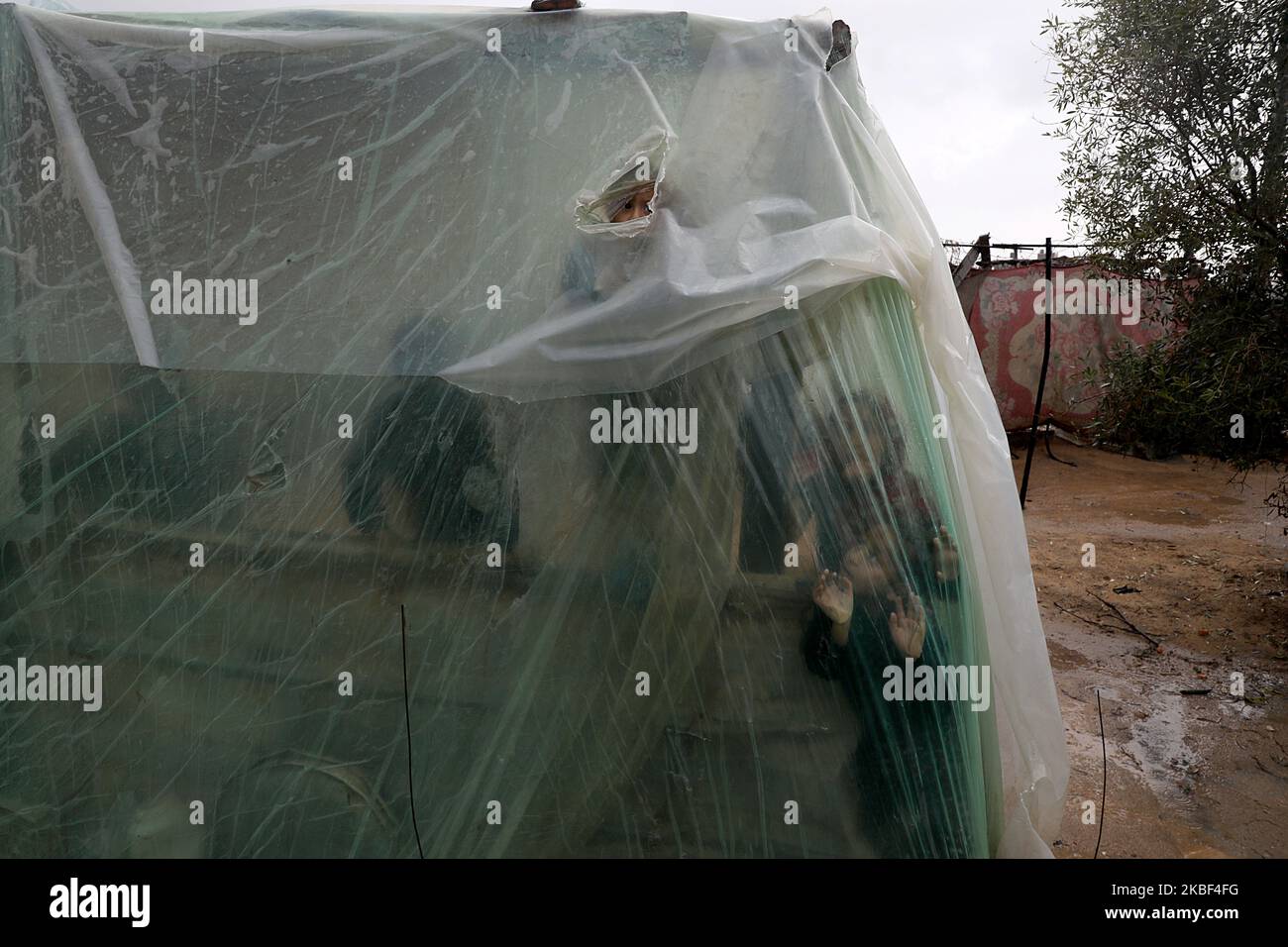 Palestinian children look outside a tent during heavey rains in Beit ...