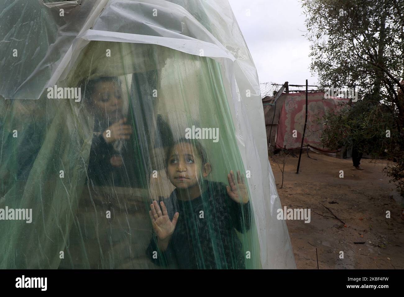Palestinian children look outside a tent during heavey rains in Beit ...