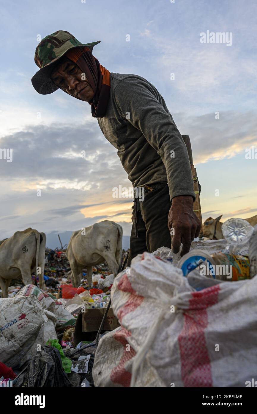 A scavenger picks up plastic waste to be recycled at the Kawatuna landfill, Palu, Central Sulawesi, Indonesia on January 22, 2020. The economic potential for recycling plastic waste is huge because based on the results of an environmental audit by Greenpeace in 2019, only 9 percent of the waste plastic is recycled, 12 percent is burned and 79 percent ends up in landfills and waterways like rivers that run into the ocean. Indonesia is the second largest waste producer in the world after China. (Photo by Basri Marzuki/NurPhoto) Stock Photo