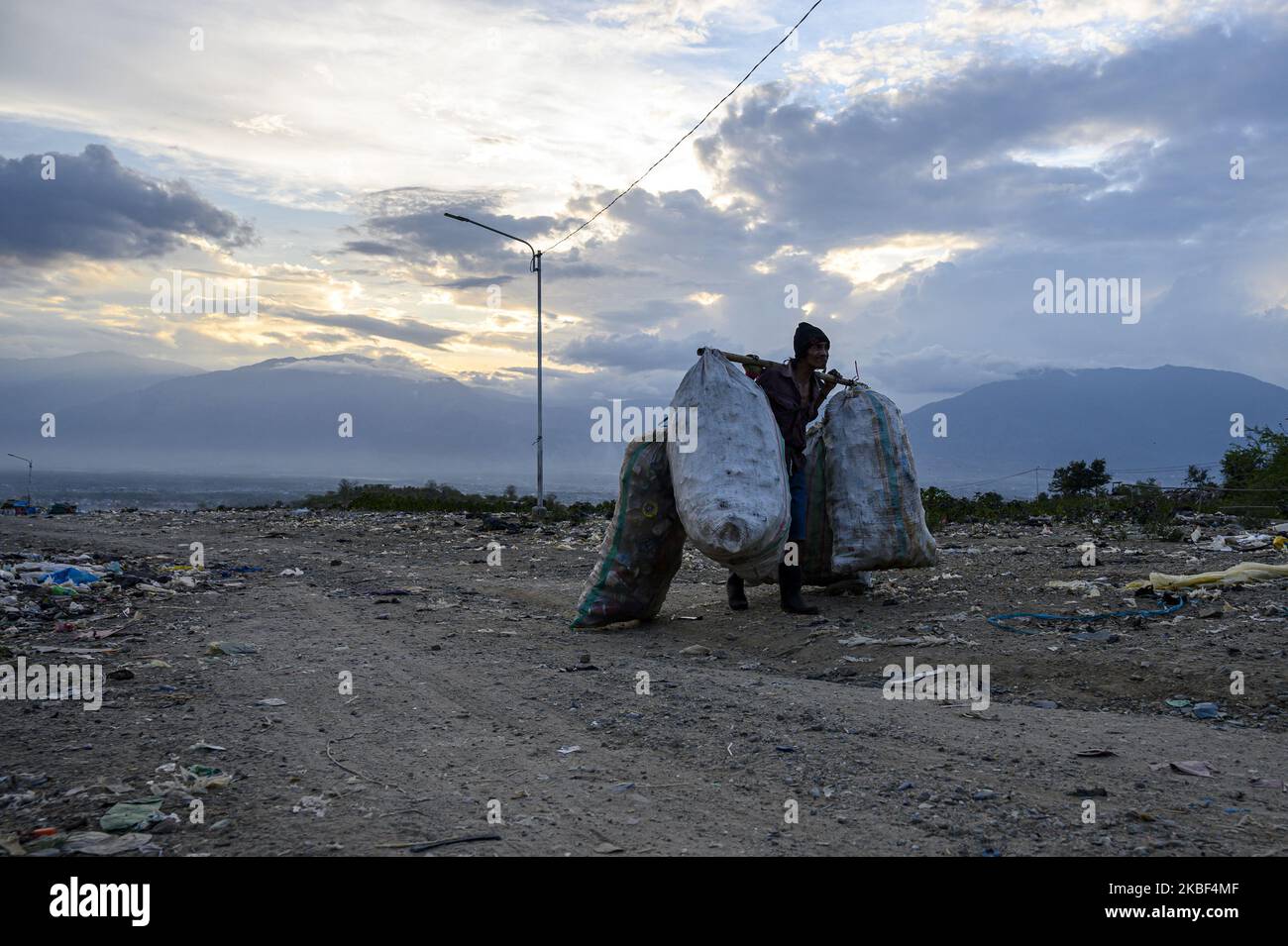 A scavenger carries plastic waste that has been collected for recycling at the Kawatuna landfill, Palu, Central Sulawesi, Indonesia on January 22, 2020. The economic potential for recycling plastic waste is huge because based on the results of an environmental audit by Greenpeace in 2019, only 9 percent of the waste plastic is recycled, 12 percent is burned and 79 percent ends up in landfills and waterways like rivers that run into the ocean. Indonesia is the second largest waste producer in the world after China. (Photo by Basri Marzuki/NurPhoto) Stock Photo