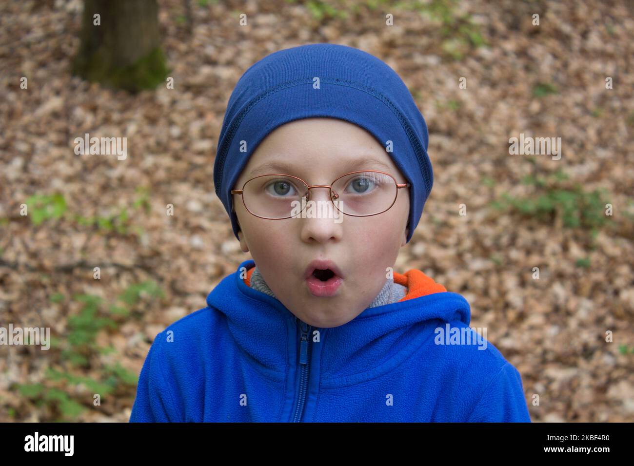 Emotion of a boy surprised at the forest in the fall Stock Photo