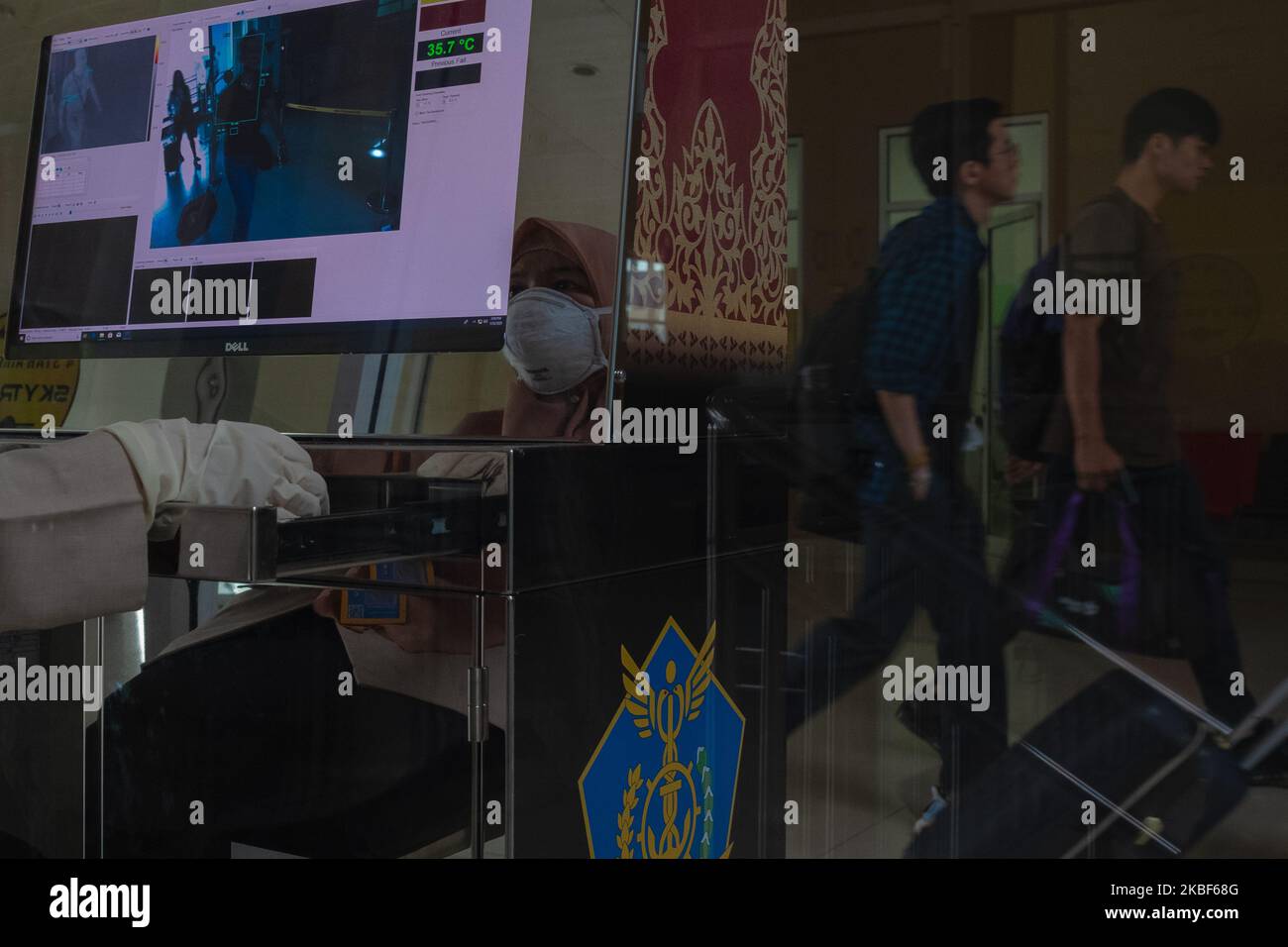 A health worker monitors a thermal scanner as passengers arrive at Sultan Syarif Kasim II airport on January 23, 2020 in Pekanbaru, Indonesia. A new virus that has killed nine people, infected hundreds and already reached the United States could mutate and spread, China warned January 21, as authorities scrambled to contain the disease during the Lunar New Year travel season. (Photo by Afrianto Silalahi/NurPhoto) Stock Photo